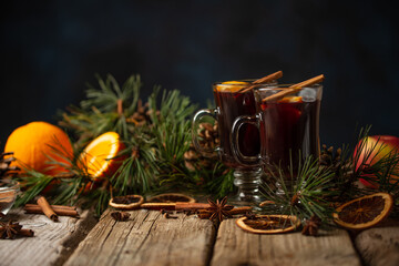 Appetizing christmas composition glasses of mulled wine on spruce cone and branch background. fragrant spices. Festive mood. Hot alcoholic drinks.