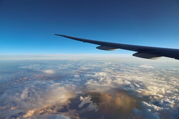 Clouds viewed from the sky with rain storm below in dramatic light