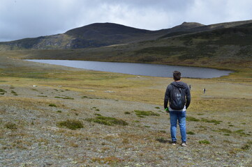 Hombre mirando el paisaje con laguna