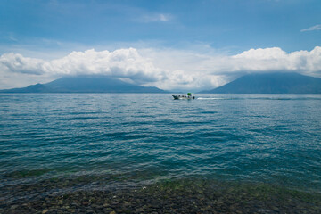 Speed boat passing by on lake Atitlan between volcanoes San Pedro and Tiloman at Santa Cruz la Laguna, Guatemala