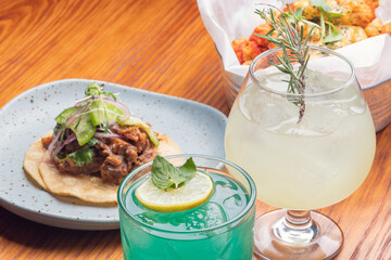 Gourmet Mexican shredded meat tacos on wooden table. Gourmet mexican food. Gourmet tacos and gin...