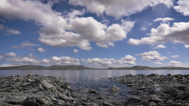 Peaceful lake scene in the afternoon with fluffy clouds and a blue sky reflecting in the still water. A calm, tranquil and serene, natural landscape.  