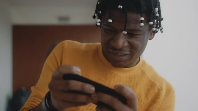 Portrait of african american black man playing games on the smartphone and winning. High quality 4k footage