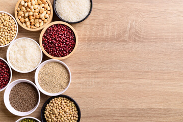 Various cereal grain in a bowl on wooden background (quinoa seeds, peanut, perilla seeds, soybean, azuki beans, rice grain and mung beans)