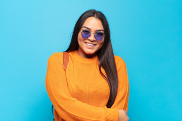 young latin woman laughing shyly and cheerfully, with a friendly and positive but insecure attitude