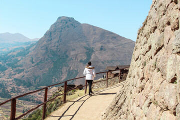 Fototapeta na wymiar Mulher andando pelas ruínas e montanhas no Peru