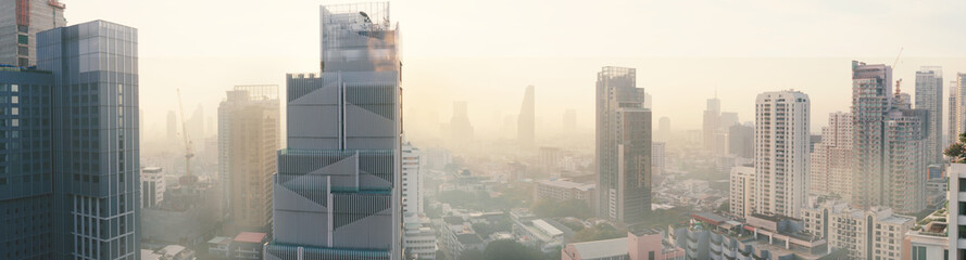 Cityscape of buildings and skyscrapers of Bangkok city covering with smog, dusk, high PM 2.5 air pollution in serious and dangerous level to health. Air quality problems concept.