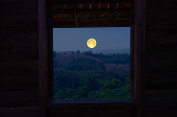 Beautiful full moon over the mountains in window view