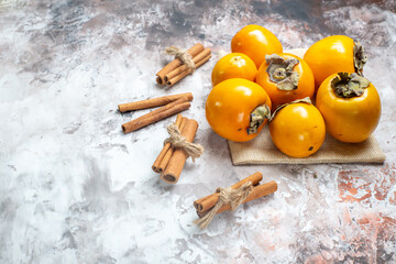 front view fresh persimmons with cinnamon on light background photo fruit tree ripe color