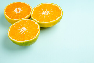 front view fresh tangerine slices on the light-blue background photo color orange citrus fruit