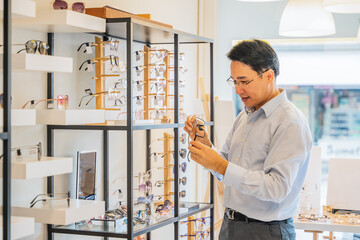 Naklejka na ściany i meble client chooing new eyeglasses frame for his new eyeglasses in optical store