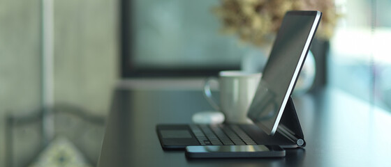 Portable workspace with tablet, smartphone and decorations in cafe
