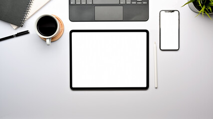 Fototapeta na wymiar Top view of worktable with tablet, smartphone, keyboard and coffee cup