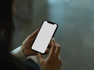 Cropped shot of businesswoman using smartphone in blurred background