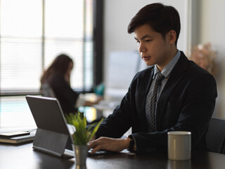 Businesswoman working with tablet in modern office room