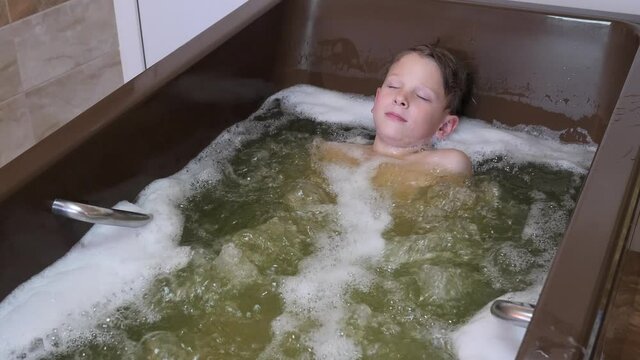 boy bathes. medical procedures hydrotherapy mineral water bubble bath 2020