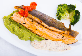 Healthy eating. Grilled fillets of steelhead trout served on white plate with boiled broccoli and tartar sauce