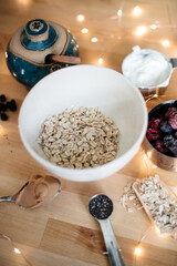 Healthy breakfast ingredients overnight oats with frozen berries, oats, peanut butter, top view 