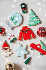Fototapeta na wymiar Adorable decorated colorful christmas cookies and gingerbread with disco ball lights flatlay on gray background