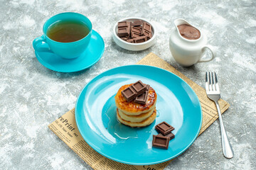 front view delicious muffins with cup of tea and chocolate on light background pancake photo color sweet cake
