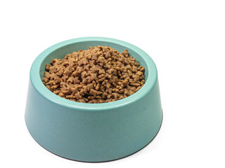 The close up of dry dog treat food in blue green plastic dog bowl, pet equipment isolated on white background.
