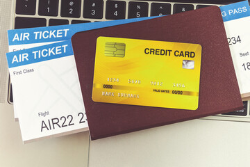 Credit card and passports near laptop computer on table. Online ticket booking concept