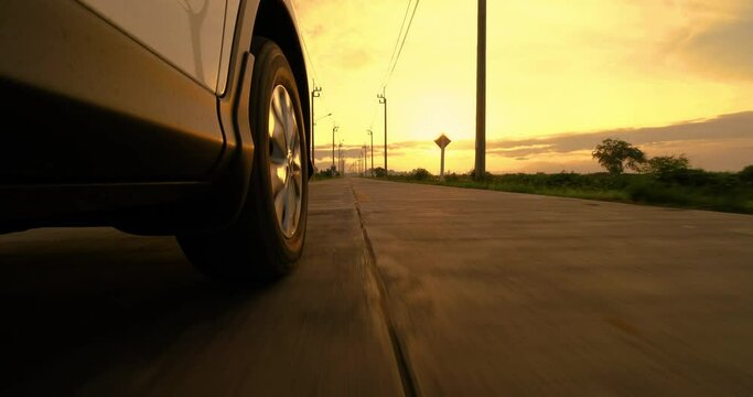 Driving a car on a country road, Wheel spinning in sunset, Low camera position
