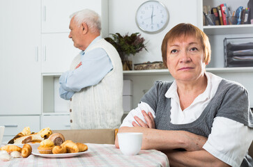 Old couple quarreled and offended at each other at table at home