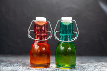 front view glass cans with liquid inside on grey background color food photo