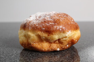 Doughnut without a hole filled with jam with sugar on top