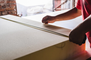 man cutting foam rubber