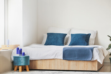Pouf with candles in interior of bedroom