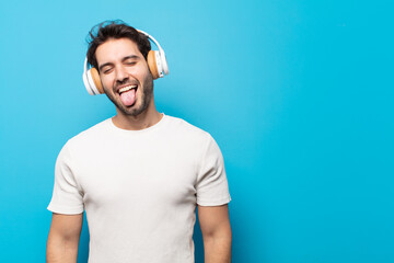 young handsome man with cheerful, carefree, rebellious attitude, joking and sticking tongue out,...
