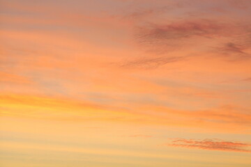 Sun below the horizon and clouds in the fiery dramatic orange sky at sunset or dawn backlit by the sun. Place for text and design