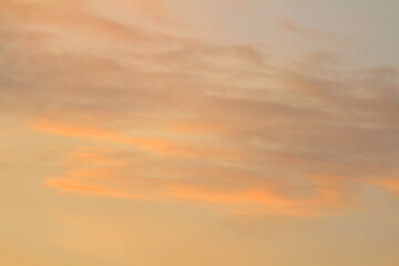 Sun below the horizon and clouds in the fiery dramatic orange sky at sunset or dawn backlit by the sun. Place for text and design