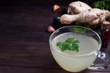 Chicken broth in a glass Cup. Boiled chicken leg quarters. Healthy food with collagen and amino acids.