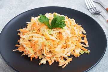 Salad of fresh grated carrots and green radish with sauce.