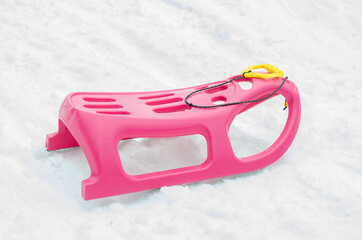 Pink and yellow plastic sleigh on for the children durrign winter