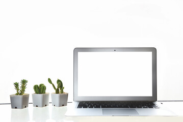 White screen computer laptop with cactus and succulents plant on the table on white wall background, copy space input text concept and smart technology idea