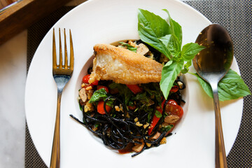 Black spaghetti from squid ink spicy food meal included roasted tomatoes, fried dolly fish and...