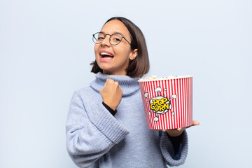 young latin woman feeling happy, positive and successful, motivated when facing a challenge or celebrating good results