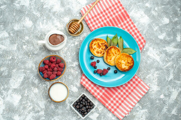 Fototapeta na wymiar top view delicious muffins with berries on light background taste dough sweet photo pancake sugar