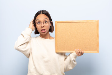 young latin woman looking happy, astonished and surprised, smiling and realizing amazing and...