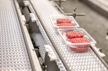 Ground beef on a conveyor belt.