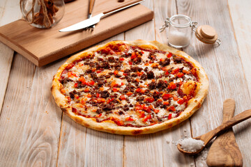 Side view on minced meat pizza on the rustic wooden background