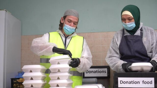 Muslim volunteers pack free hot meals in take out boxes. Charities Coronavirus (COVID-19) Response Fund. Holiday dinners and food. Free groceries, Food donation and charity on Ramadan