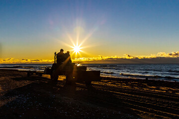 tractor drives along the seaside with sea grass