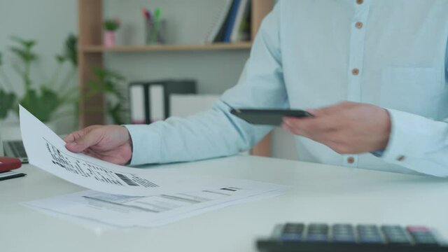 The hand uses the phone to scan the QR code to receive a discount from paying electricity bills at the office