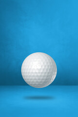White golf ball on a blue studio background
