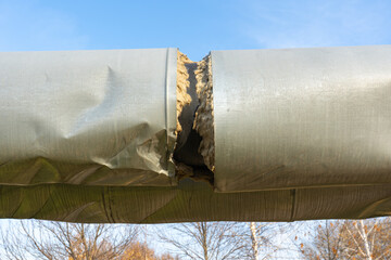 Damaged Central heating pipe. Break in the insulation of the heating main